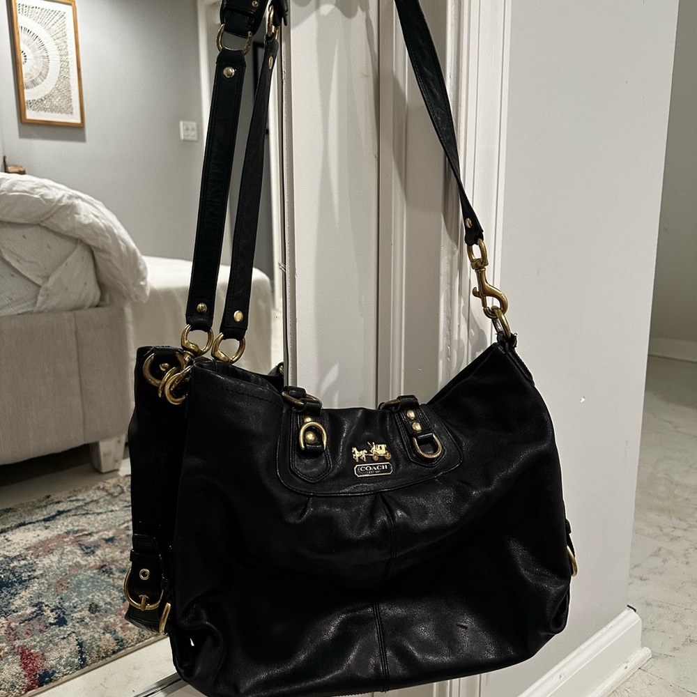 An antique smooth black leather coach bag.